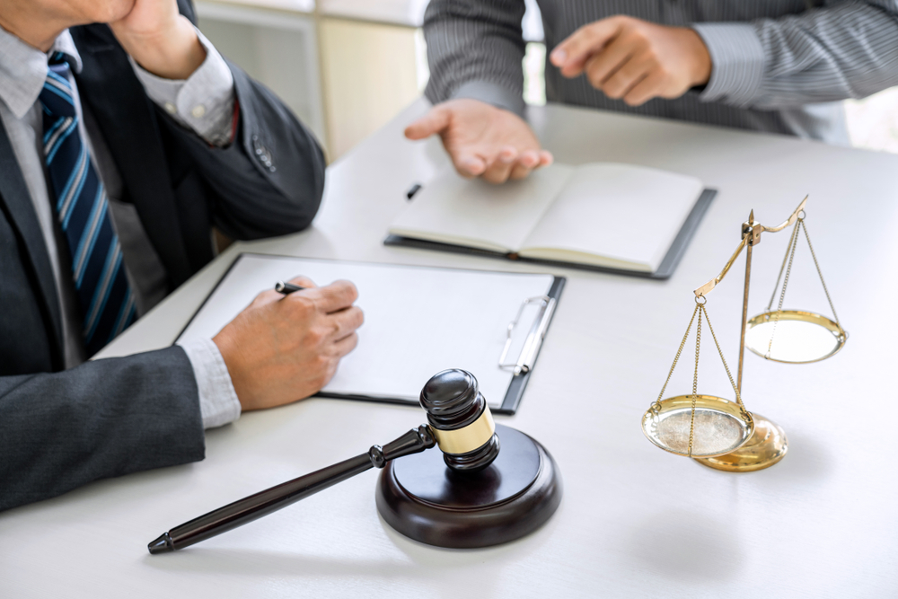 Judge gavel with scales of justice, Businessman and lawyer or counselor consulting and discussing contract papers at law firm in office.